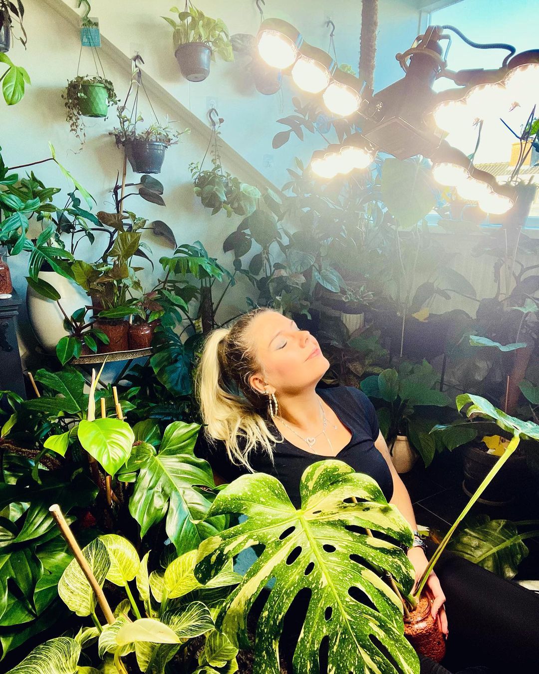 A photo shared by an influencer @junglefever_nl on INS,She stood under the 60W folding wings plant grow light, with her eyes closed, bathed in the light of the plant grow light without any harm, and surrounded by the plants she planted, which was very artistic.